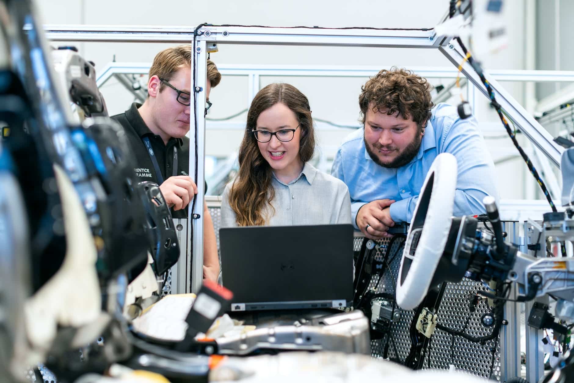 Image of group of robot automation experts looking at a laptop at a customers premise for an automation project